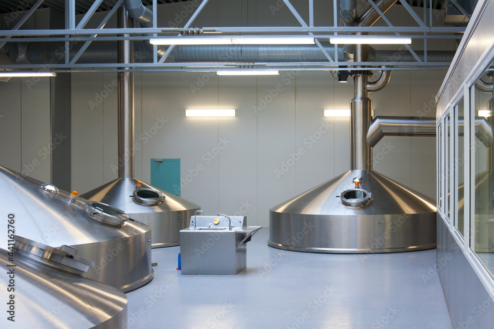 Interior of brewery, large steel storage tanks for brewing beer. Interior of brewery, large steel storage tanks for brewing beer.