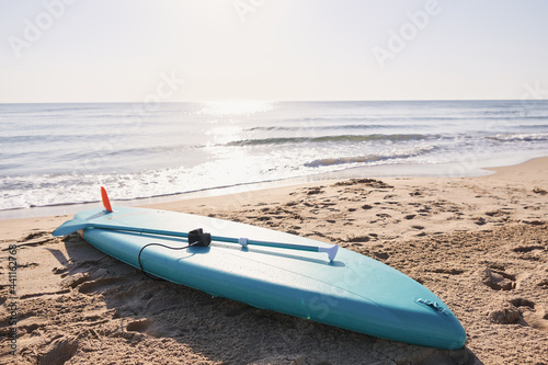 Bild auf Leinwand Paddle surf board in the sand on the beach at sunrise