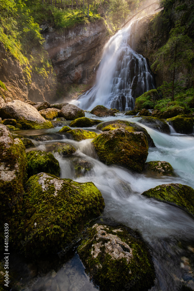 Fototapeta premium Gollinger Waterfall in Golling an der Salzach near Salzburg, Austria. Gollinger Wasserfall with mossy rocks and green trees, Golling, Salzburger Land, Austria.