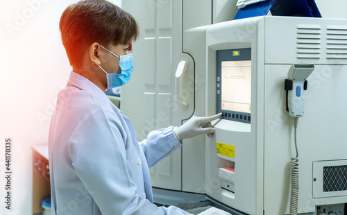 Lab staff or laboratory technician working with scientific equipment for antimicrobial susceptibility testing of bacterial isolates in hospital.