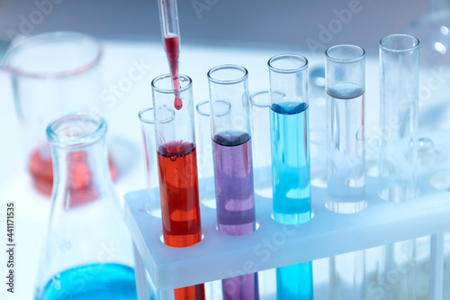 Closeup of laboratory glass tubes and pippete, colorful chemical liquids