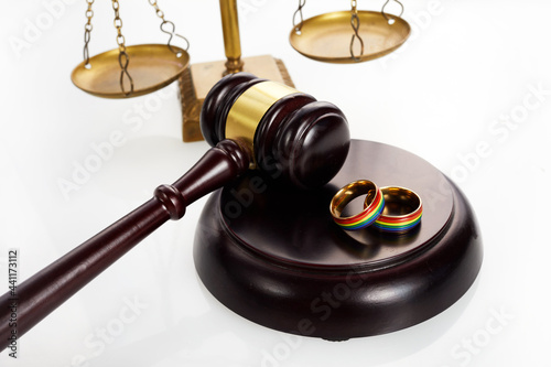 Two gold wedding rings with lgbt rainbow colours. Homosexual marriage. Lgbt rights and law.