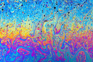 Fluid soap bubble psychedelic colorful abstract art. Surreal patterns with rainbows and waves of color in motion.