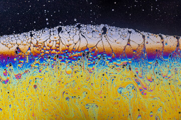 Fluid soap bubble psychedelic colorful abstract art. Surreal patterns with rainbows and waves of color in motion.