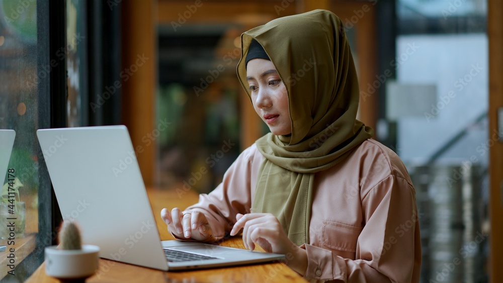 Young muslim woman use laptop for working in coffee shop Young muslim woman use laptop for working in coffee shop