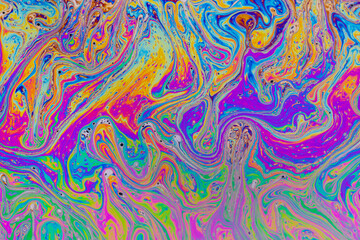 Fluid soap bubble psychedelic colorful abstract art. Surreal patterns with rainbows and waves of color in motion.