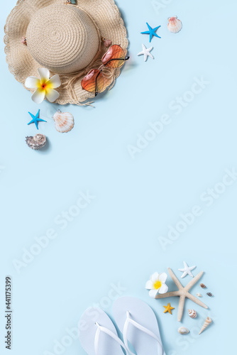Summer beach background design concept with shells, hat, slipper on blue background.