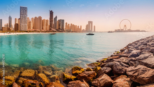 Wide panorama of the Persian Gulf with famous Ferris wheel Dubai Eye and numerous skyscrapers with hotels and residences. Travel and vacation destinations