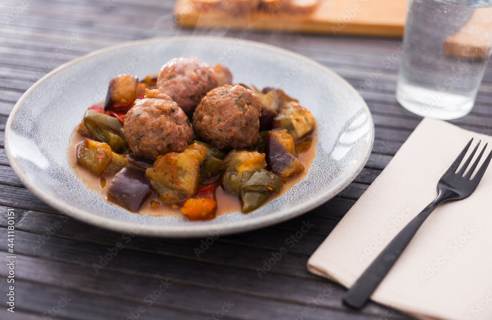 baked meatballs with stewed eggplant, zucchini, green peppers and tomatoes with haze in bowl baked meatballs with stewed eggplant, zucchini, green peppers and tomatoes with haze in bowl