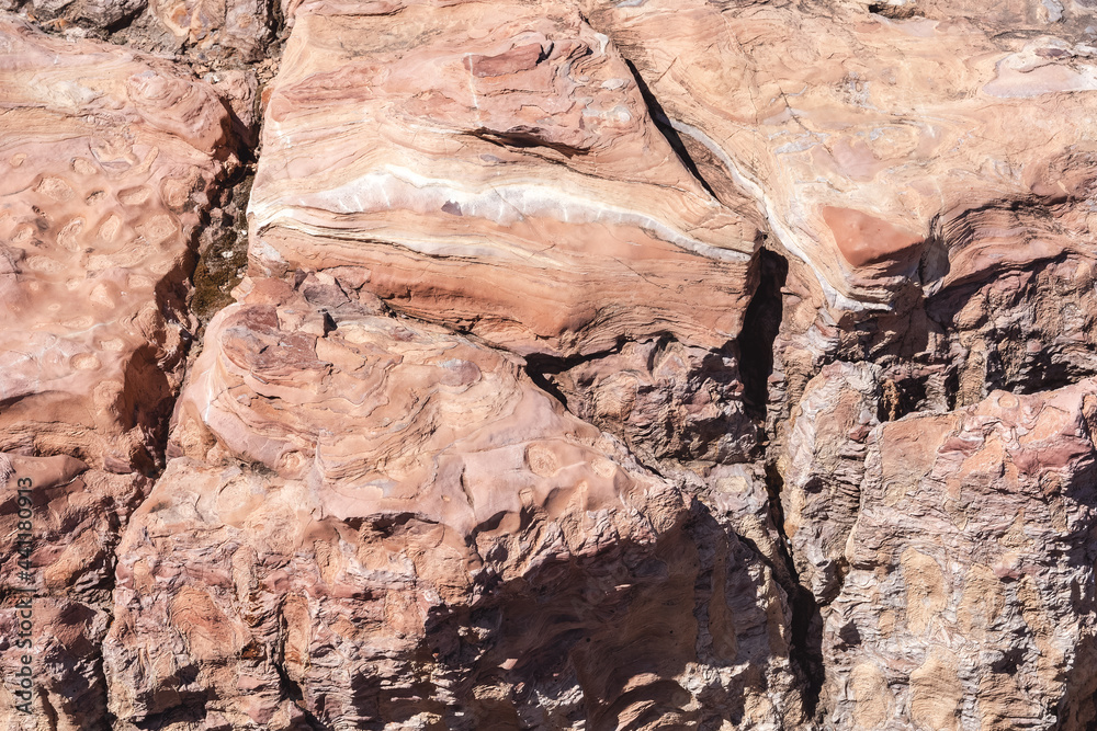 Unique colorful pattern of crumbling rock with deep cracks. Texture and natural background of sandstone. Unique colorful pattern of crumbling rock with deep cracks. Texture and natural background of sandstone.