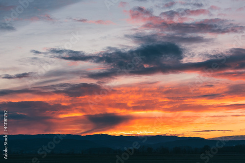 Natural Sunset Sunrise Over Field Or Meadow. Bright Dramatic Sky And Dark Ground. Countryside Landscape Under Scenic Colorful Sky At Sunset Dawn Sunrise. Sun Over Skyline, Horizon. Warm Colours. © daliu