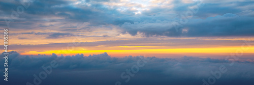 Beautiful sunset sky above clouds with dramatic light. Cabin view from airplane. Flying above the clouds. view from the airplane. Beautiful blue sky background with sunset. Sunset above the clouds.