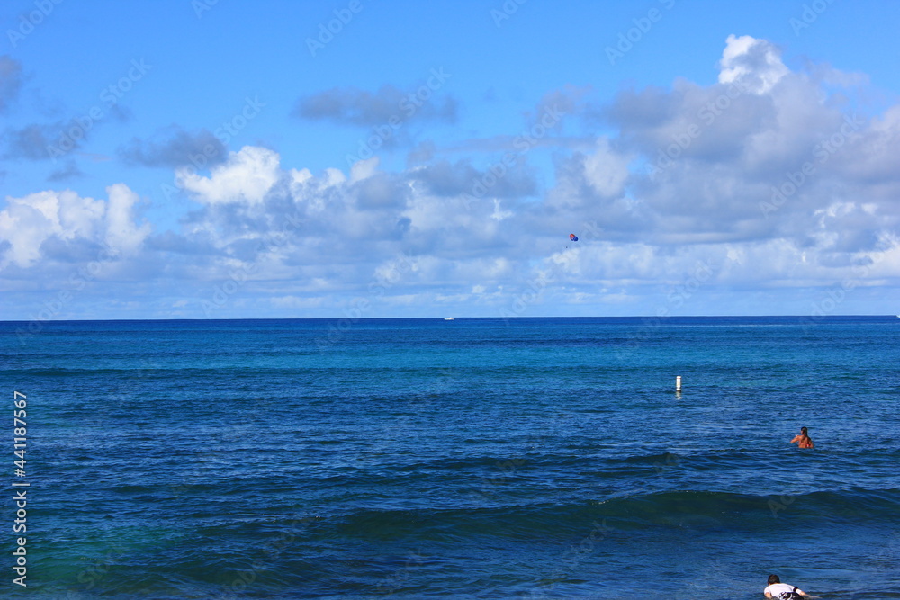 ハワイ・オワフ島・ホノルル、ワイキキビーチ。青い海、青い空、白い雲	。
