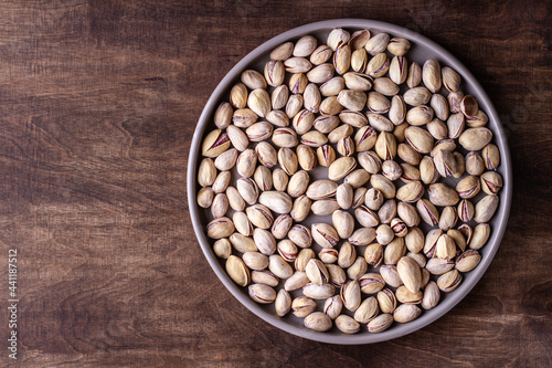 Pistachios on a round plate, free space