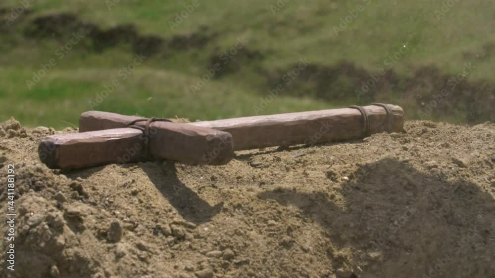 Wooden cross falling on dusty ground - super slow motion