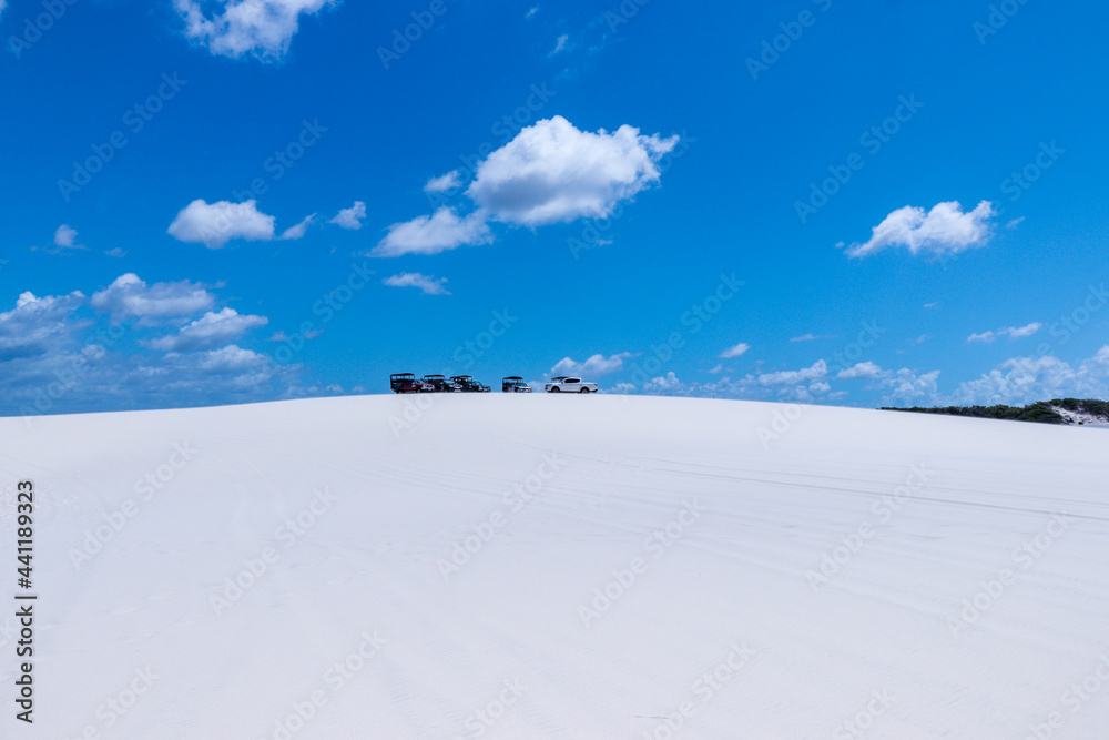Cars parked on the paradisiacal dunes of the Brazilian desert