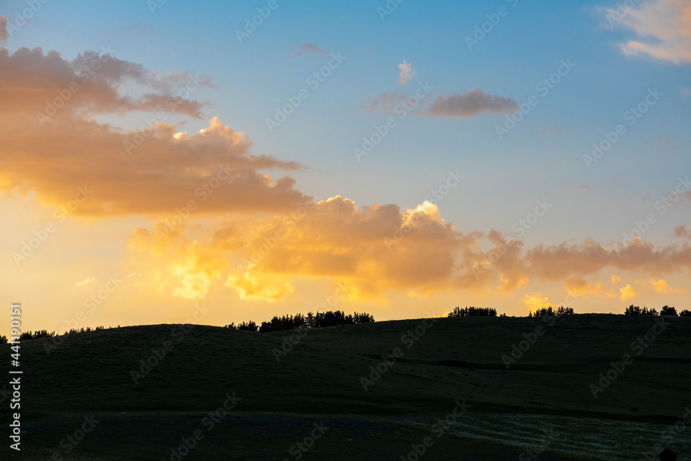 Bright golden sunset sky, and mountains silhouette. Nature sky mountains background.