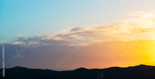 Bright golden sunset sky, and mountains silhouette. Nature sky mountains background.