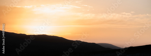 Fototapeta Naklejka Na Ścianę i Meble -  Bright golden sunset sky, and mountains silhouette. Nature sky mountains background.