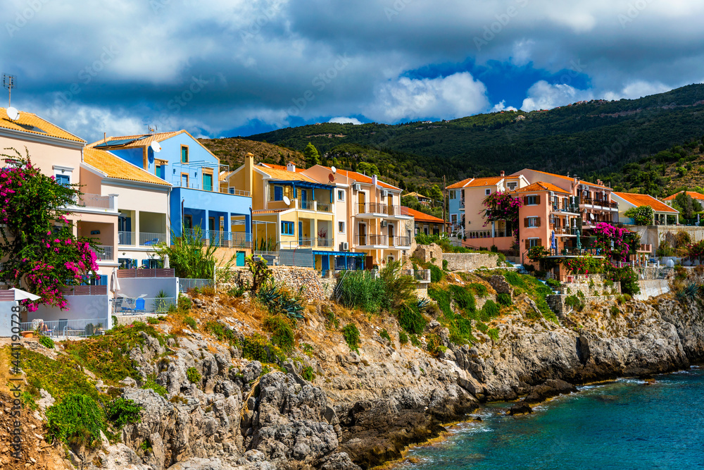 Assos village in Kefalonia, Greece. Turquoise colored bay in Mediterranean sea with beautiful colorful houses in Assos village in Kefalonia, Greece, Ionian island, Cephalonia, Assos village.