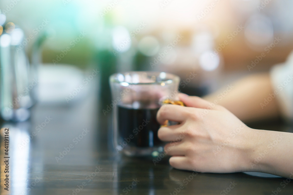 暖かい雰囲気の空間で、コーヒーを飲む若い女性