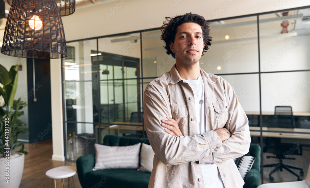 Fototapeta premium Portrait of young male business owner standing in rented open plan office space