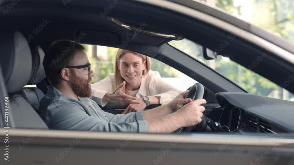 Female dealer presenting salon of new car to male client