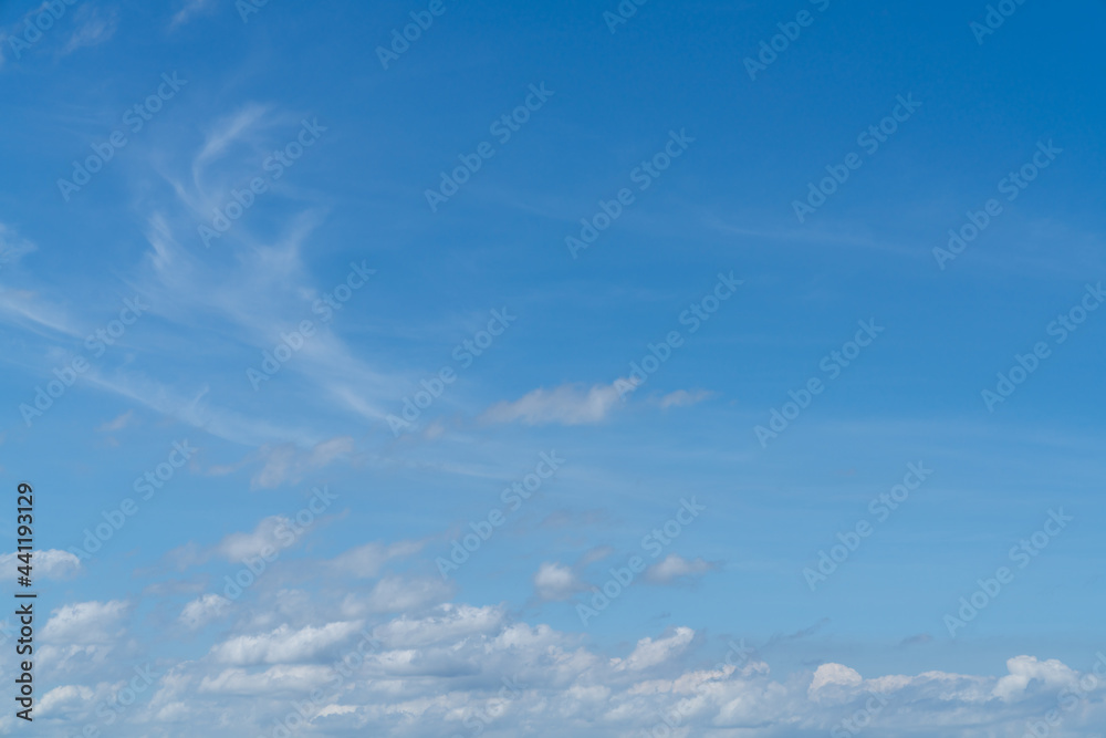 large image of bright blue sky with small fluffy white clouds, bright day