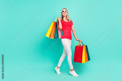 Full length body size photo woman going on shopping wearing stylish sunglass isolated bright teal color background © deagreez