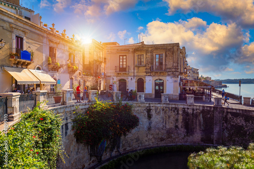 The Fountain of Arethusa and Siracusa (Syracuse) in a sunny summer day. Sicily, Italy. The Fountain of Arethusa in Ortygia, historical centre of Syracuse, Sicily, Italy.