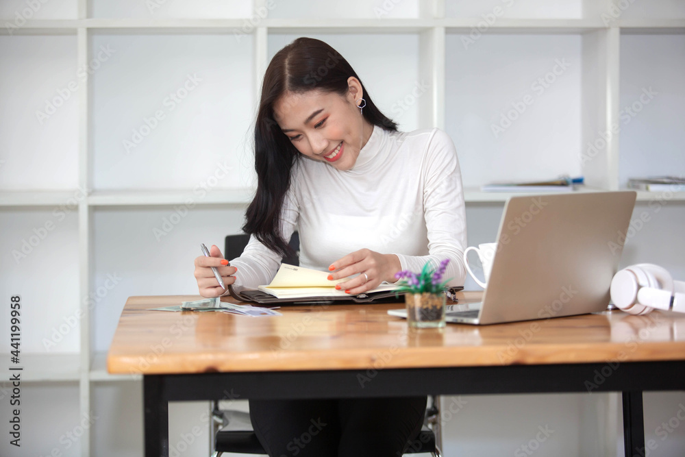 ฺPortrait of Beautiful  Asian woman working happily and success in work and profit in business made by using PC Laptop Smart phone