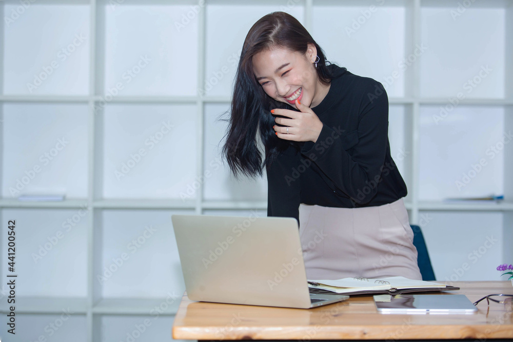 ฺPortrait of Beautiful Asian woman working happily and success in work and profit in business made by using PC Laptop Smart phone ฺPortrait of Beautiful Asian woman working happily and success in work and profit in business made by using PC Laptop Smart phone