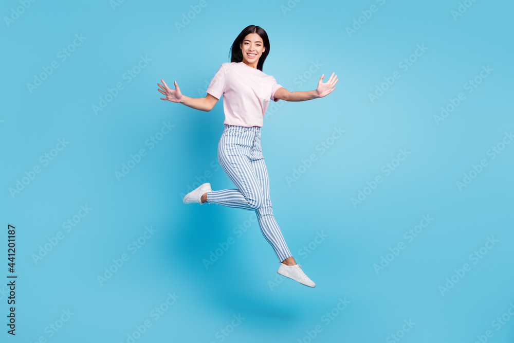Full body profile side photo of young asian girl happy positive smile have fun jump isolated over blue color background