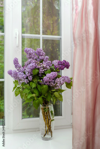 Bouquet of lilac in a vase on the windowsill