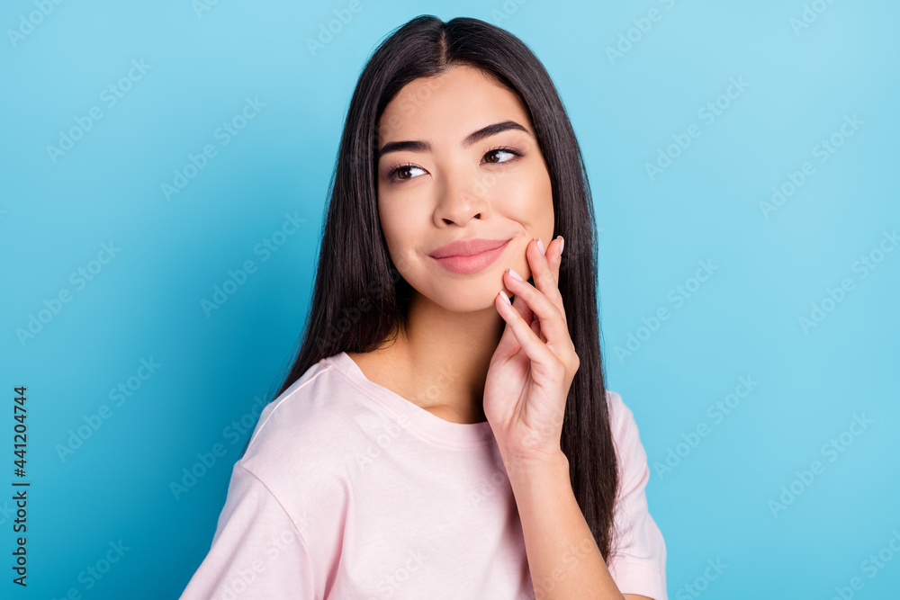 Portrait of attractive sweet cheery girl looking aside touching perfect skin isolated over bright blue color background