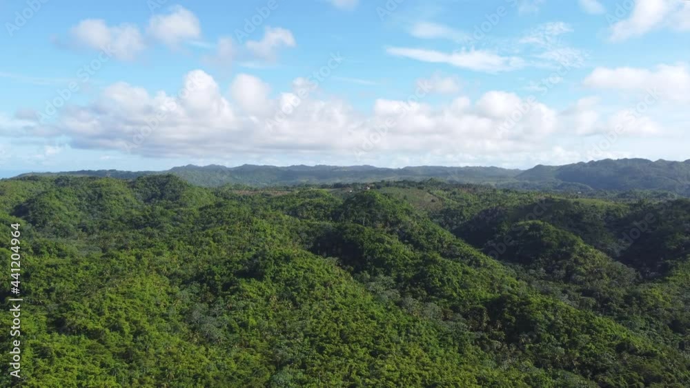 Aerial view of green hills and mountains against blue sky with white clouds. Beautiful wildlife and nature of Planet Earth Aerial view of green hills and mountains against blue sky with white clouds. Beautiful wildlife and nature of Planet Earth