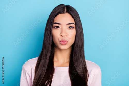 Photo of charming satisfied black hair young lady kiss lips look camera isolated on blue color background © deagreez