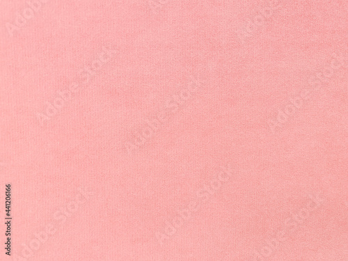 light orange-pink velvet fabric texture used as background. Empty light orange fabric background of soft and smooth textile material. There is space for text.