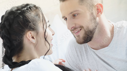 happy woman looking at bearded boyfriend at home. © LIGHTFIELD STUDIOS