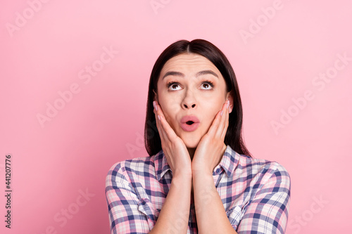 Portrait of lovely amazed girl wearing checked shirt looking up pout lips copy space isolated over pink pastel color background © deagreez