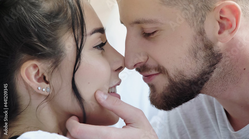 close up of bearded man touching face of happy brunette woman.