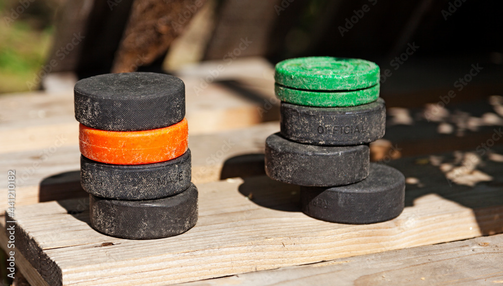 two piles of well-used hockey pucks
