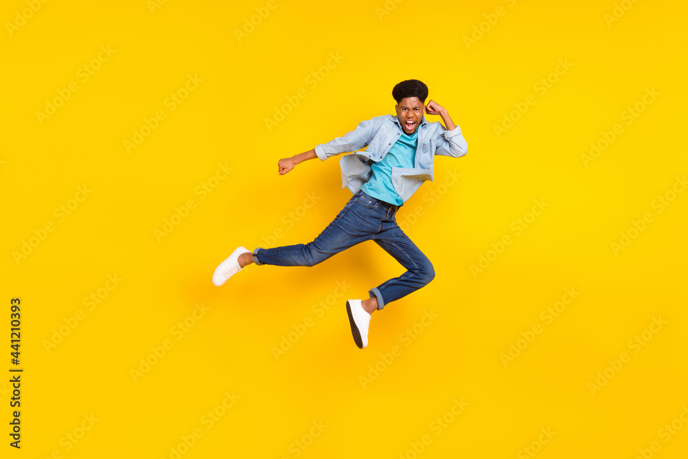 Photo of strong cool dark skin guy dressed denim shirt practicing karate jumping high isolated yellow color background