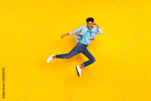 Photo of strong cool dark skin guy dressed denim shirt practicing karate jumping high isolated yellow color background
