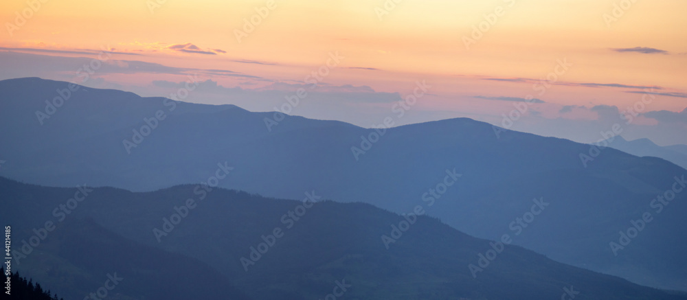 Panorama, smoky silhouette of the Carpathian mountains at sunset