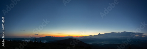 Panorama of the Carpathian mountains at sunset and the lights of the village in the haze, rest and travel in the mountains © onyx124