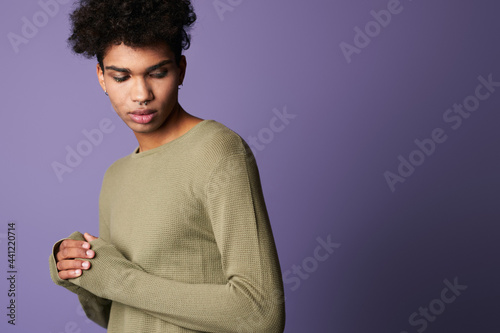 Portrait of young dark skinned brunette man in casual t-shirt. Hispanic male on purple background © Kostiantyn