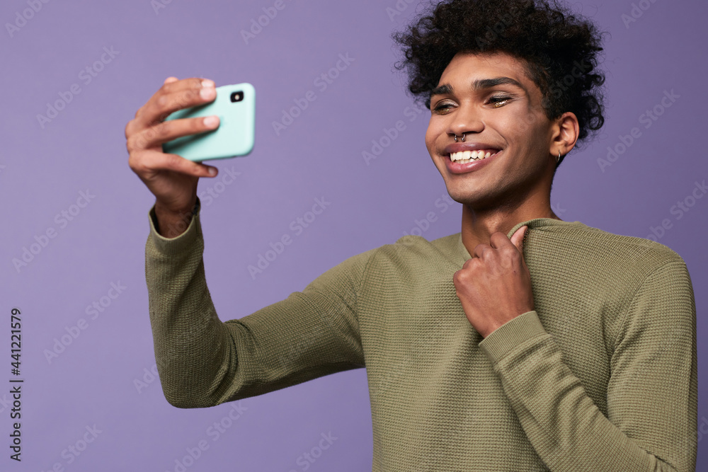 Portrait of transgender latino male taking selfies with mobile in hand. Happy trans gender young man - obrazy, fototapety, plakaty 