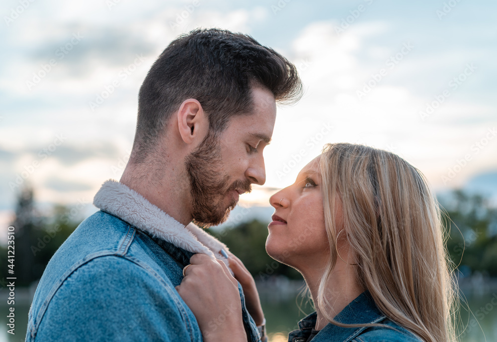 woman grabbing her boyfriend's jacket with a beautiful sunset in the background woman grabbing her boyfriend's jacket with a beautiful sunset in the background