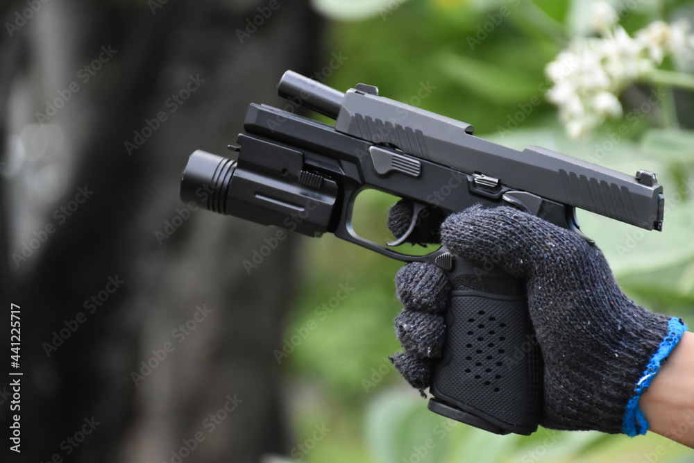 Automatic black 9mm pistol in hands ready to pull the trigger aiming to ...